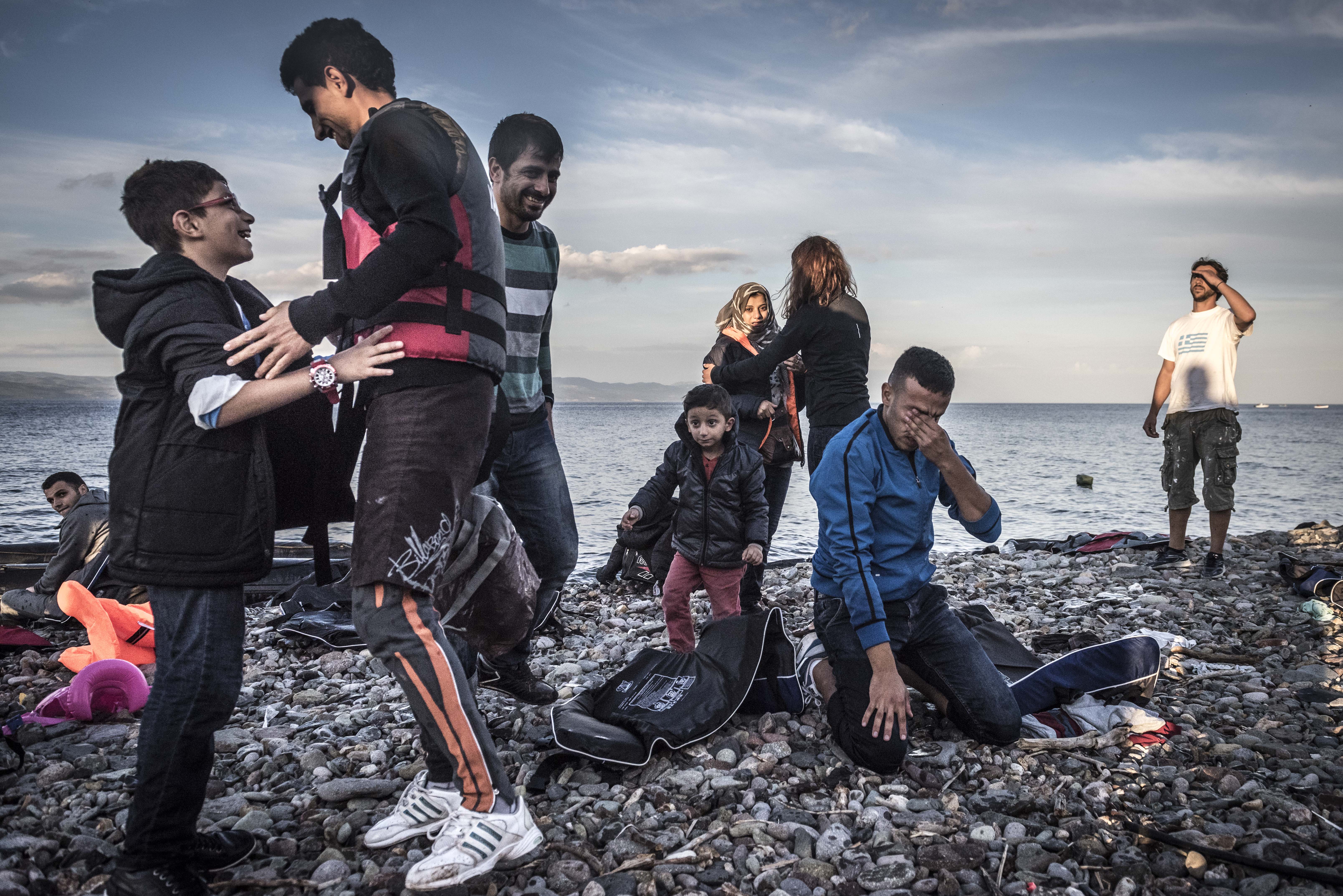 Refugees reacts after arriving safely by broken raft to Lesbos island, Greece, Monday October, 12, 2015. (Photo Sergey Ponomarev for The New York Times)